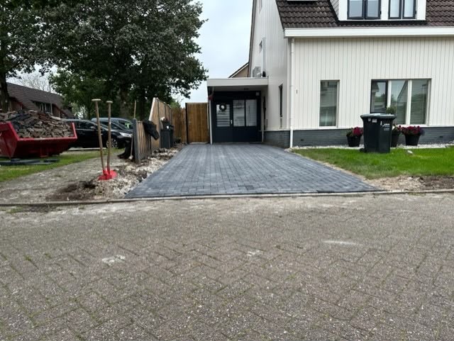 Aangelegde donkere oprit met sierbestrating