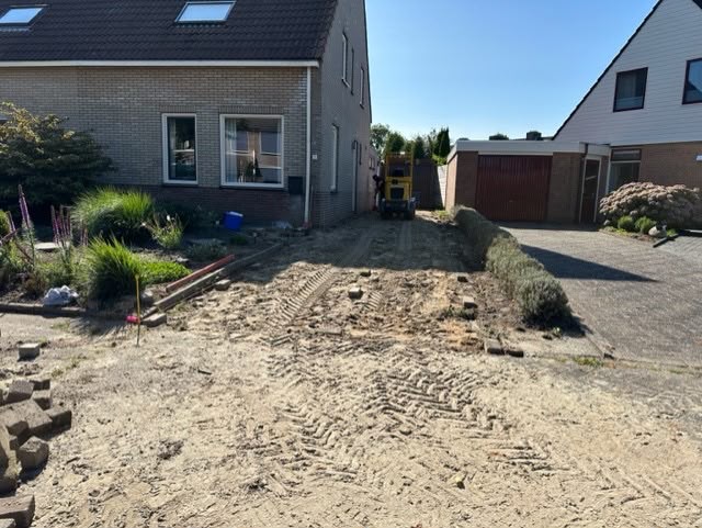 Minigraver aan het werk bij een tuinproject